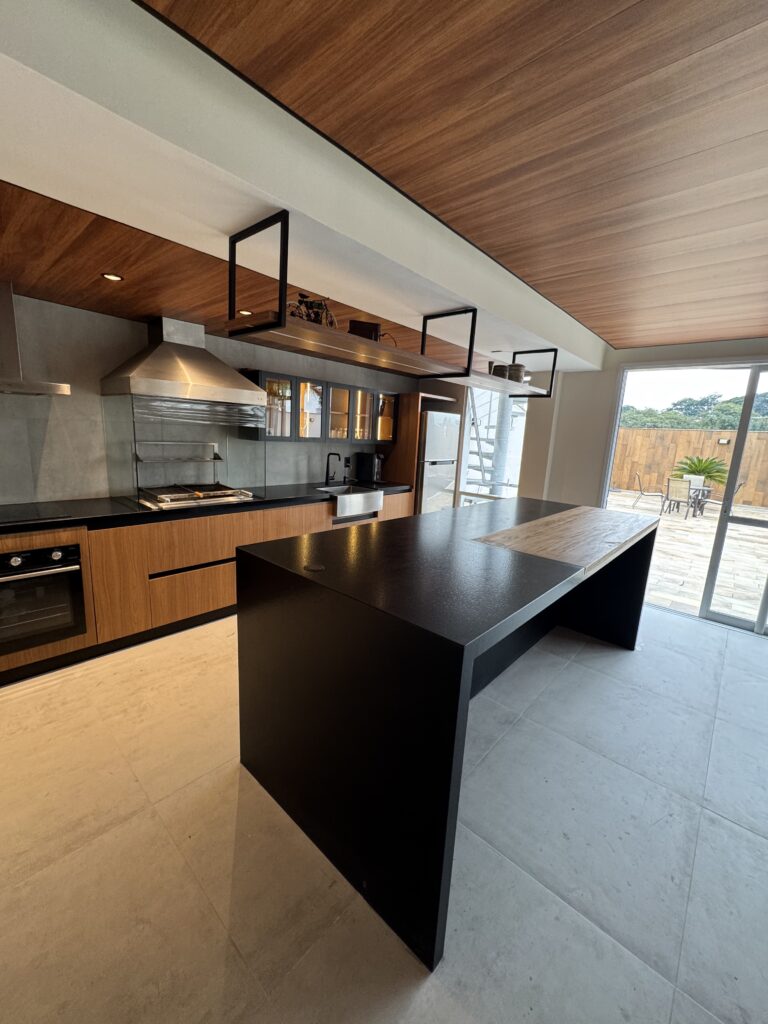 Cozinha planejada com ilha em pedra escura