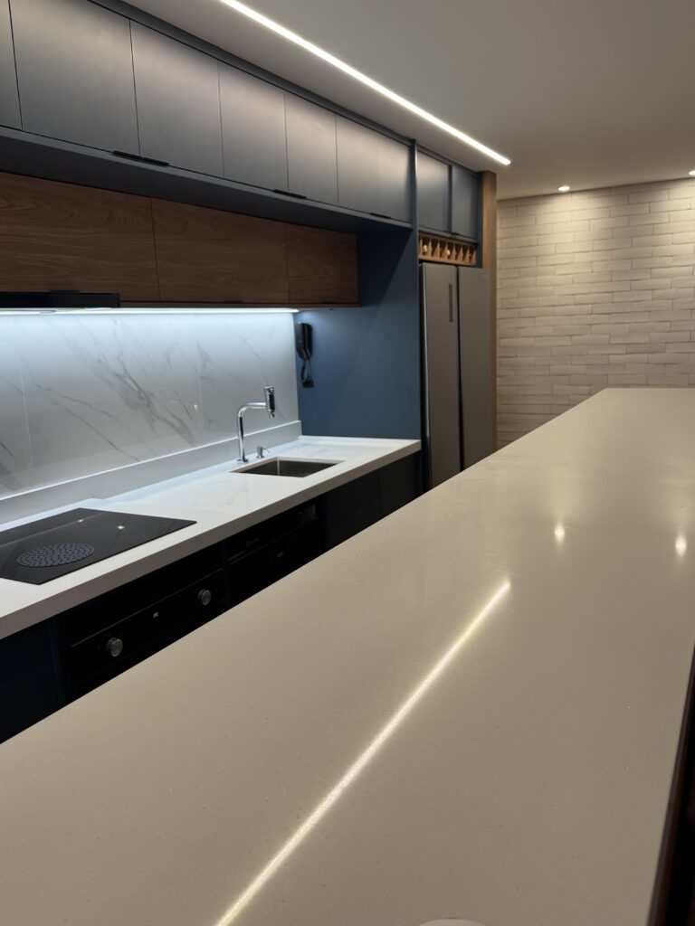 Bancada de cozinha em pedra clara com cooktop embutido